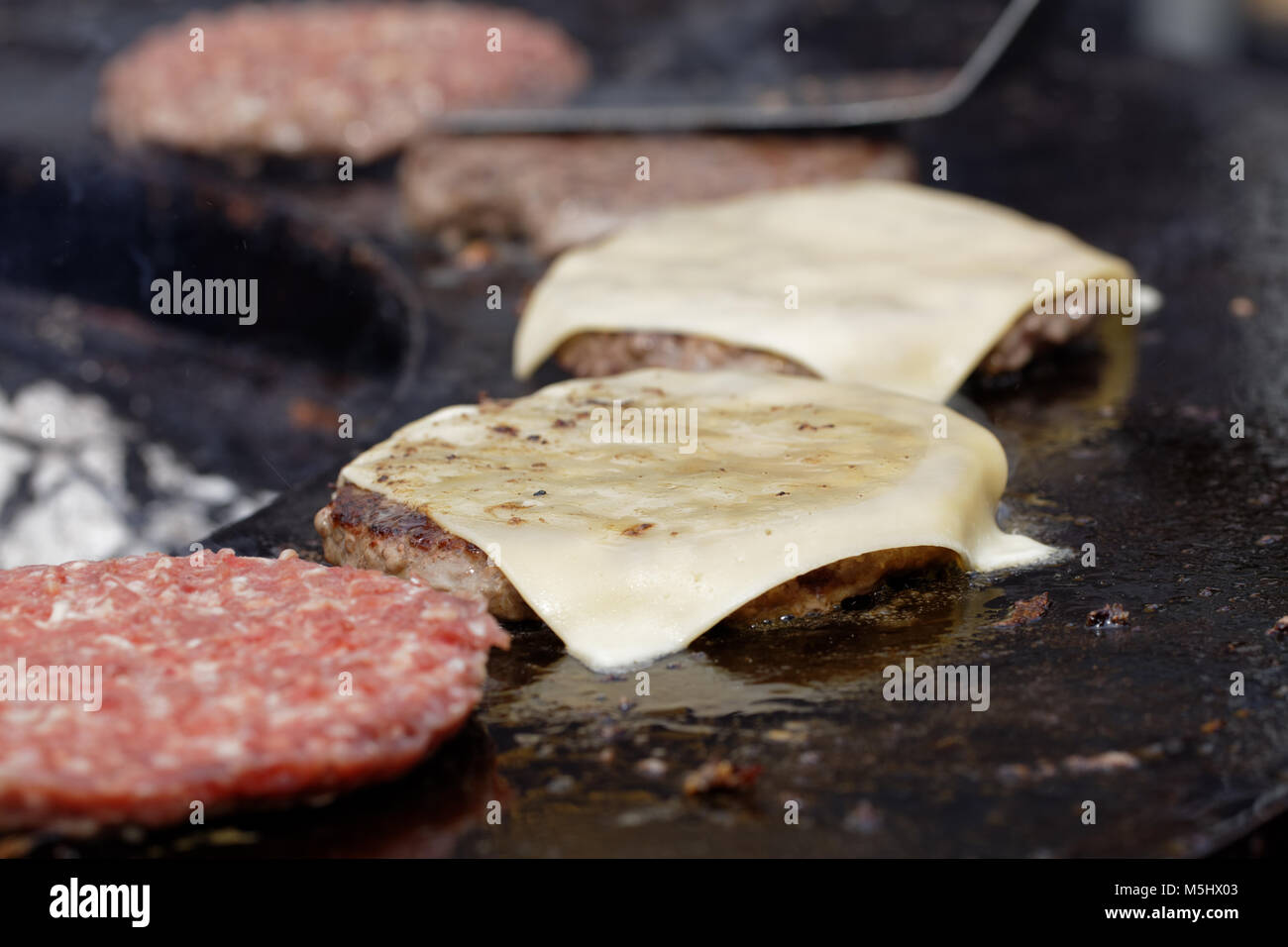 Roasting burgers on an outdoors stove in a street food restaurant Stock Photo