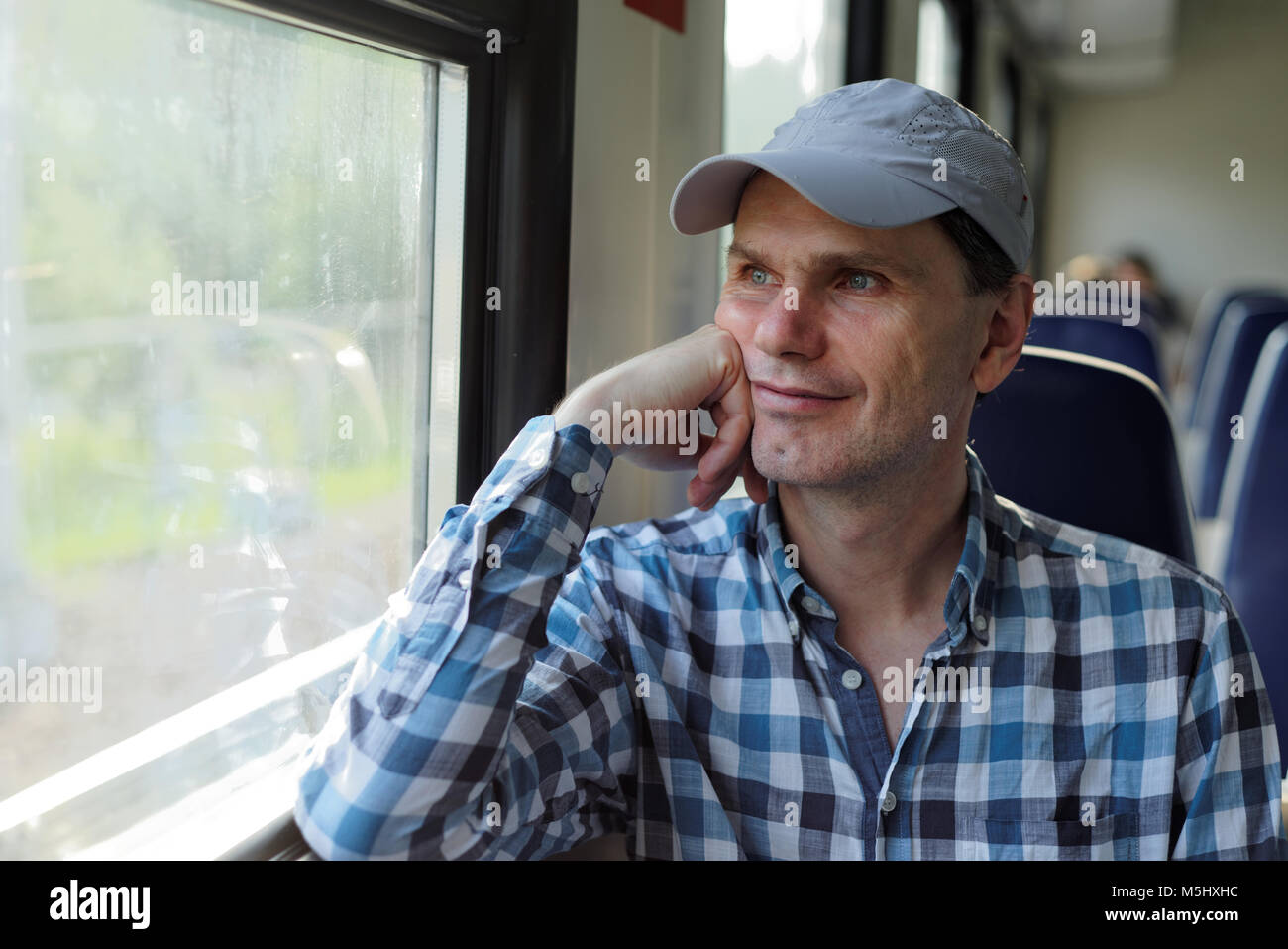 Mature man looking through the window in a commuter train Stock Photo