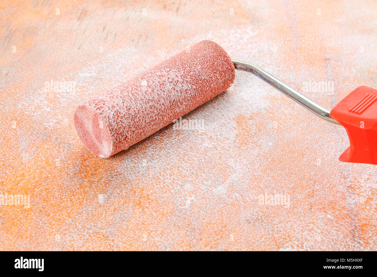 paint roll brush in white paint on plywood surface Stock Photo Alamy