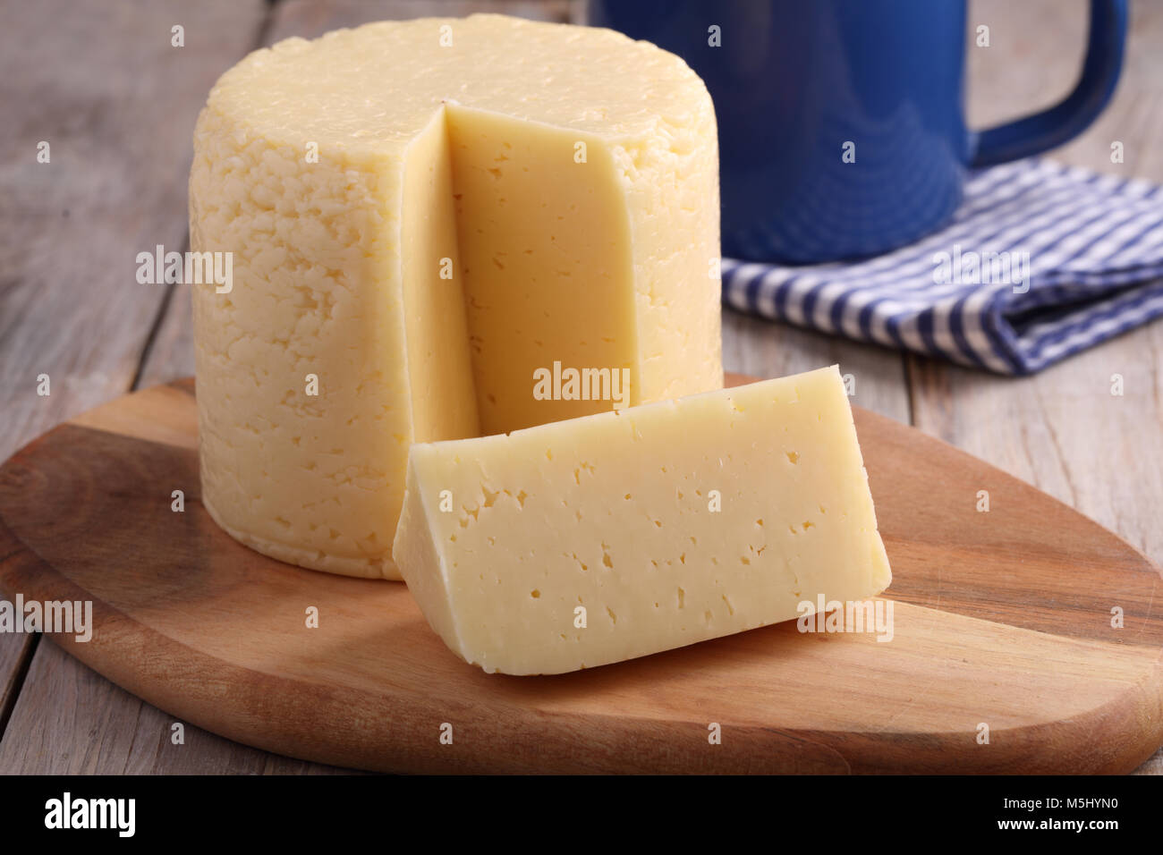 Cheese round on a rustic table Stock Photo - Alamy