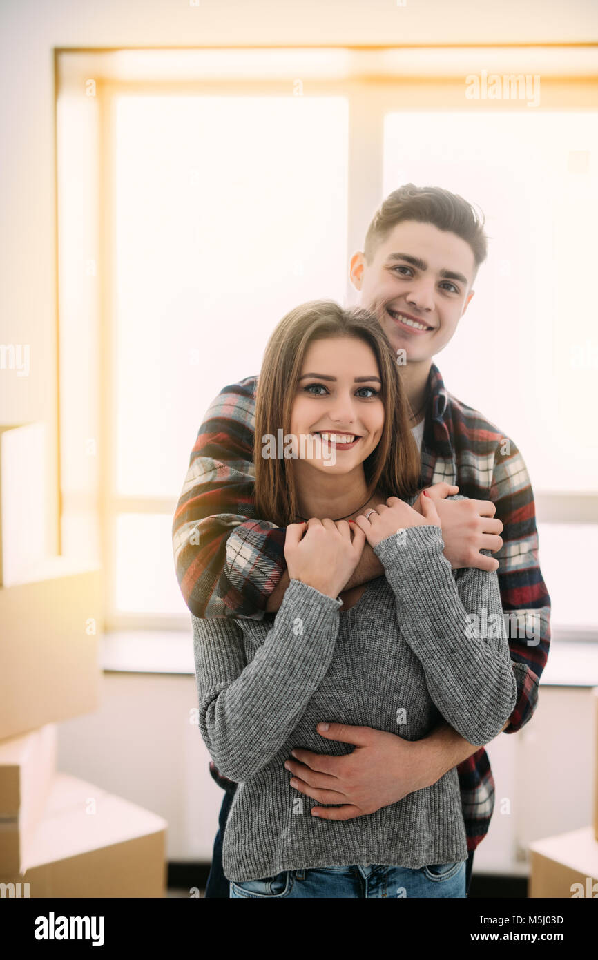 Cute couple hugging and smiling in their new home Stock Photo - Alamy