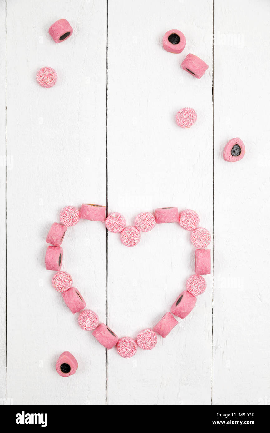 British licorice, heart on wooden background Stock Photo Alamy