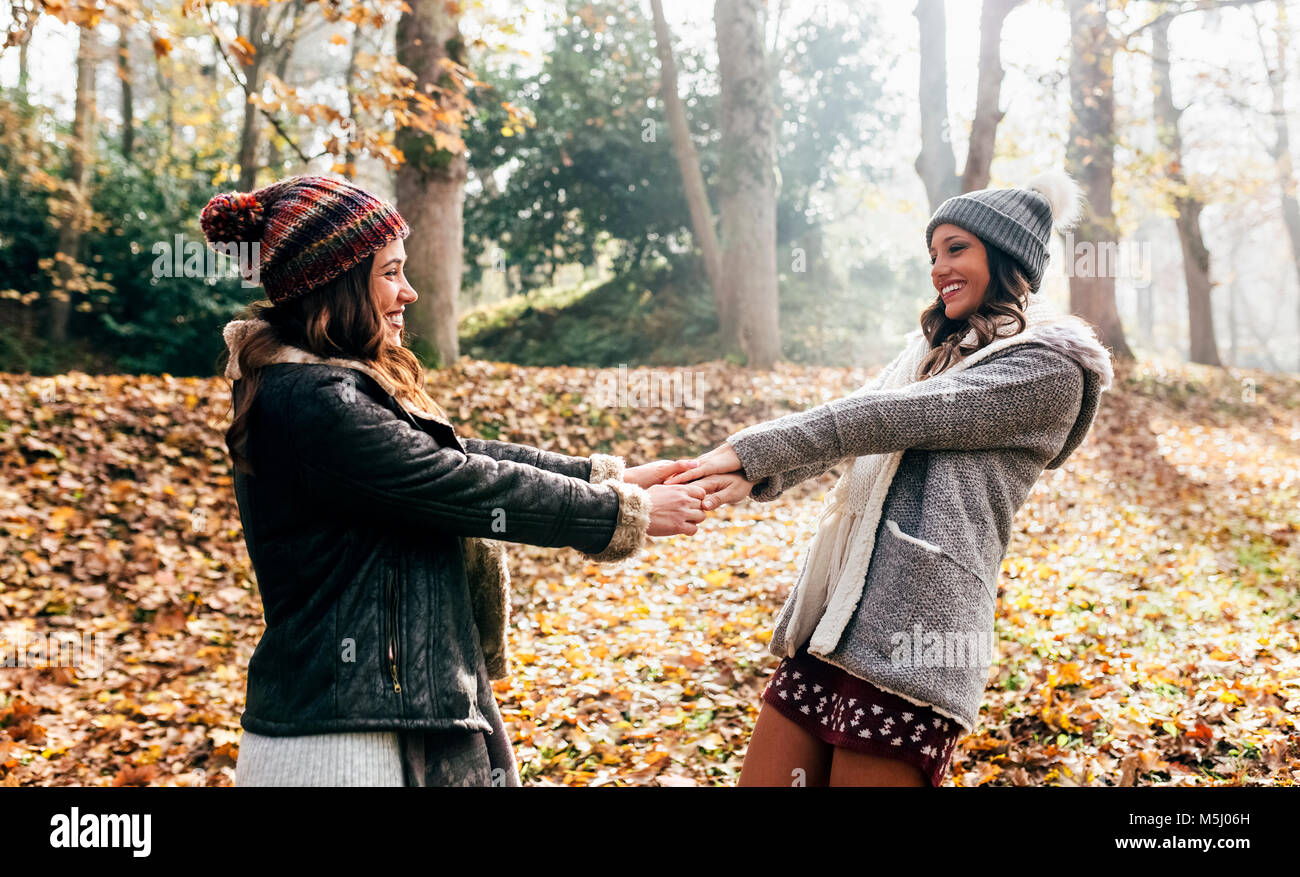 Two pretty women having fun in an autumnal forest Stock Photo - Alamy