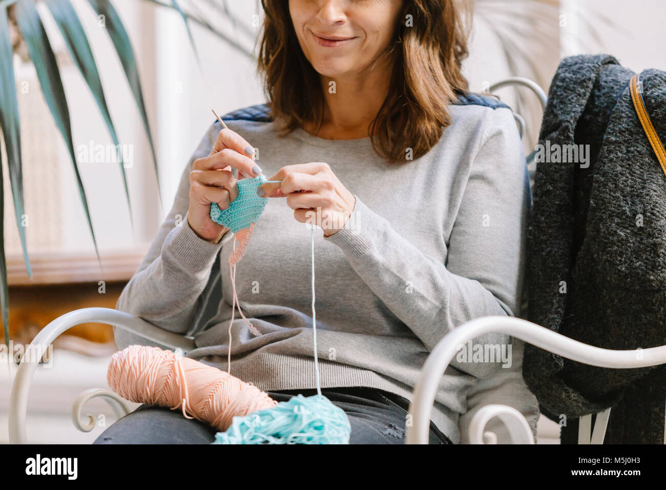Close-up of woman sitting on chair knitting Stock Photo - Alamy