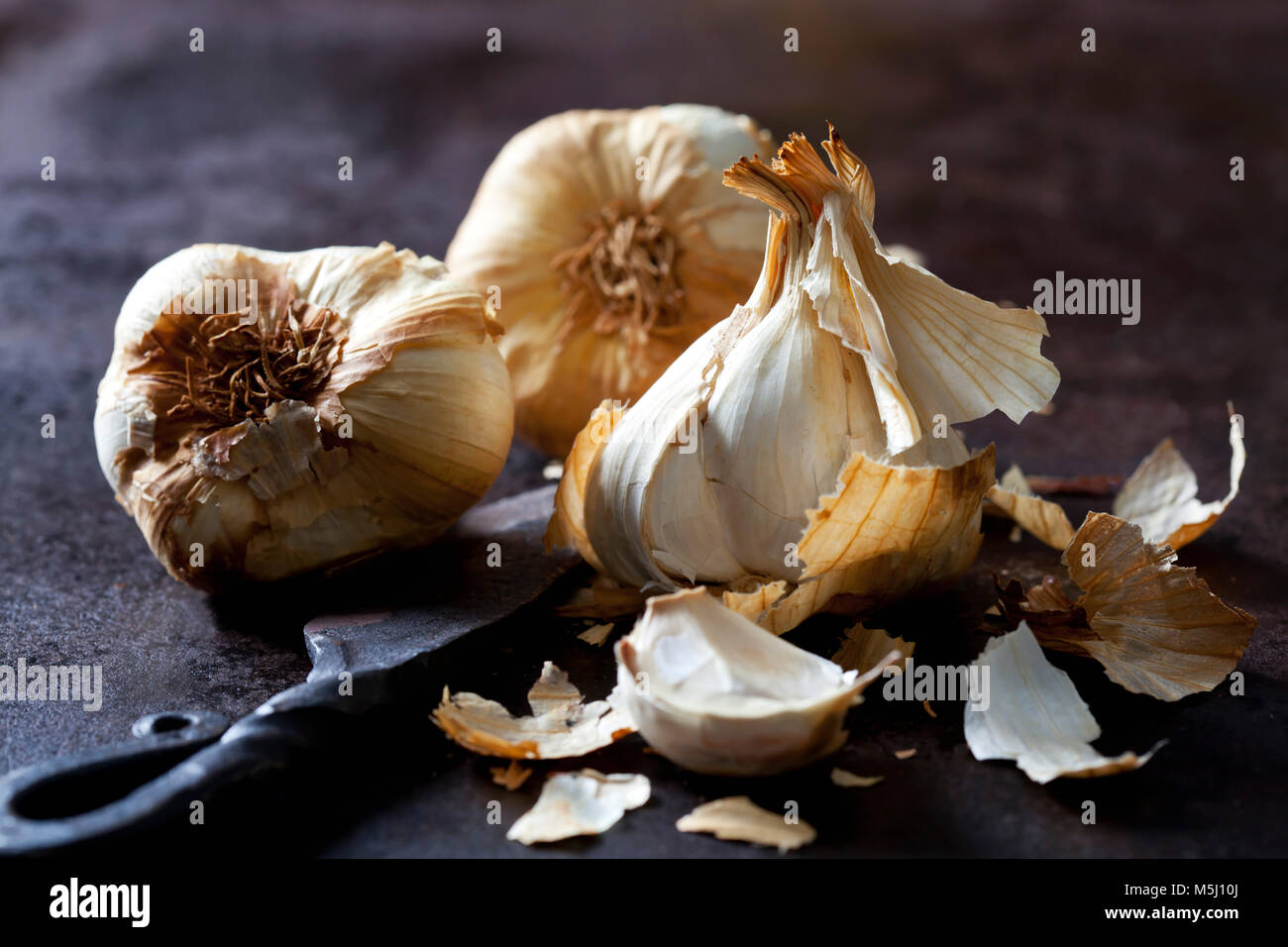 Smoked garlic on rusty ground Stock Photo