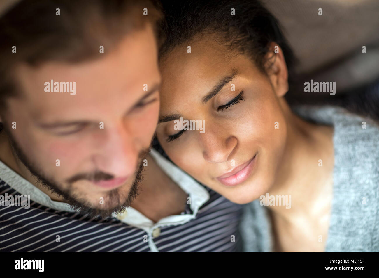 Portrait of young woman with head on shoulder of her partner Stock Photo