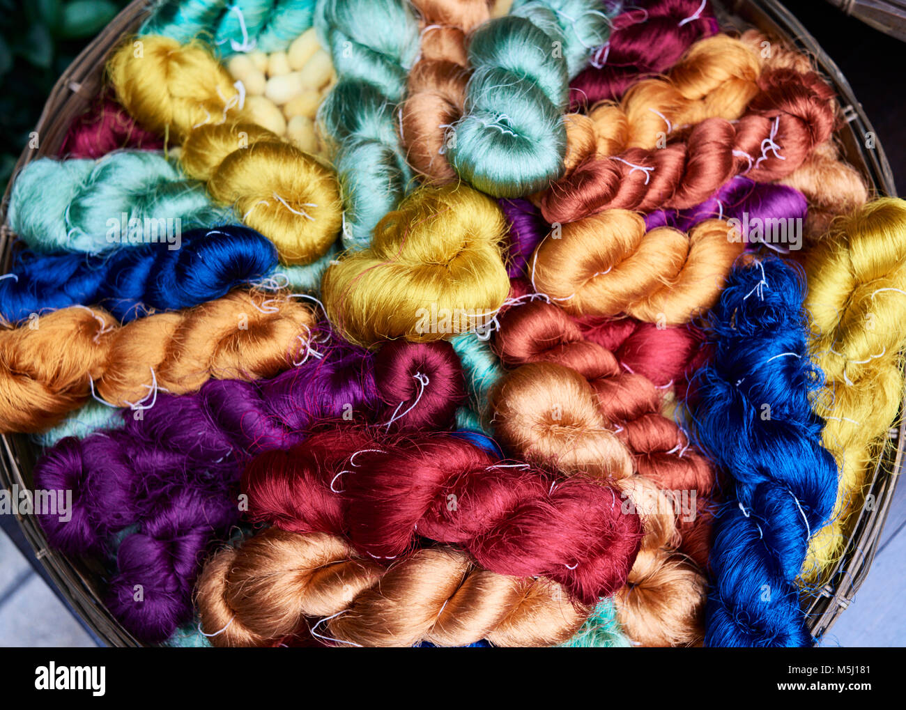 Colorful silk fiber lots in a basket, Bangkok Thailand. Stock Photo
