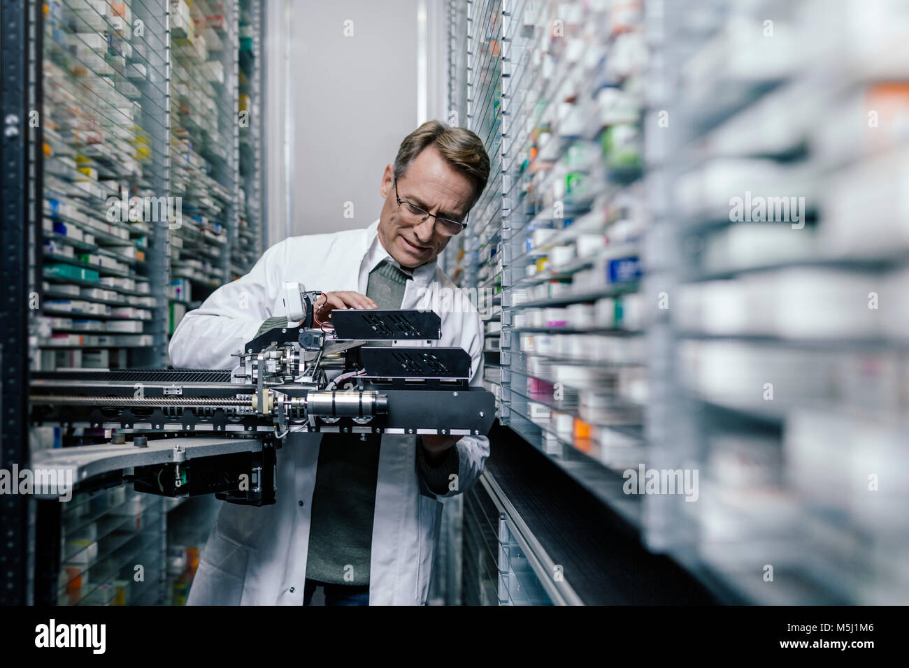 Pharmacist examining commissioning machine in pharmacy Stock Photo Alamy