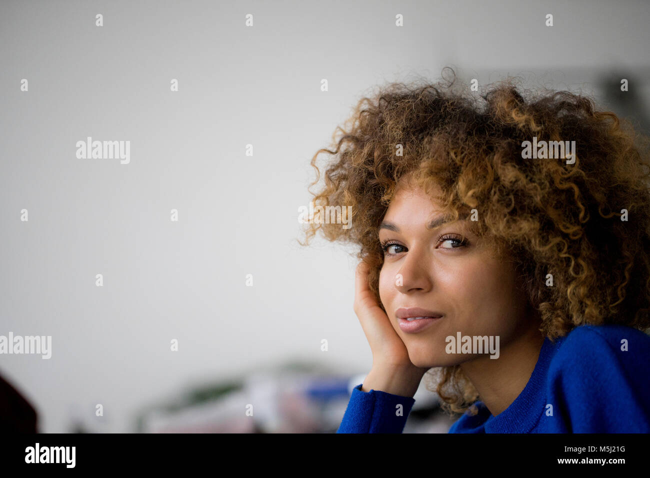 Portrait of smiling woman with hand on face Stock Photo