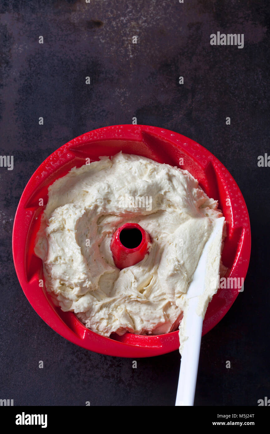 Batter in red cake pan Stock Photo