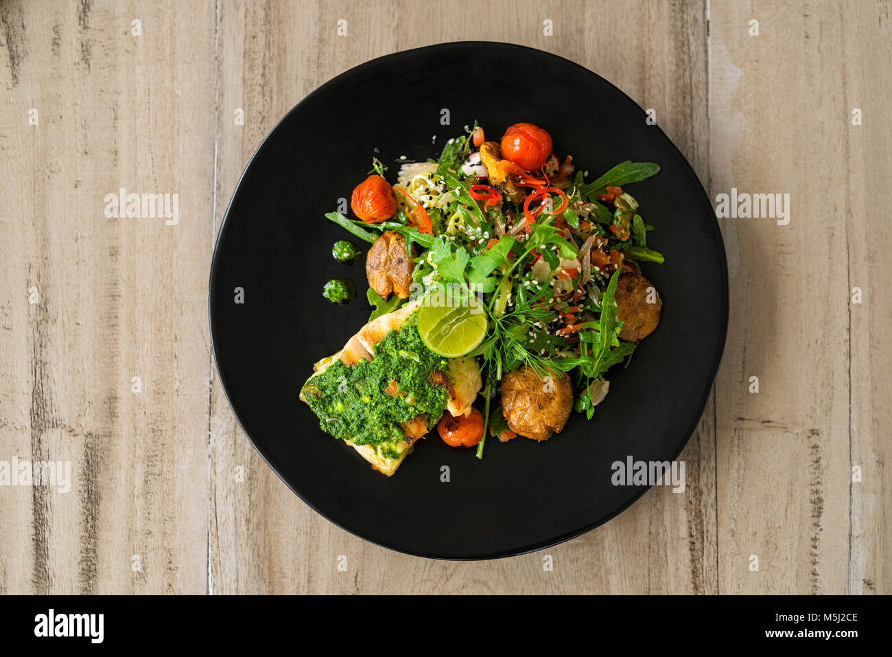 Beautifully decorated salad with fish, pesto and lime Stock Photo