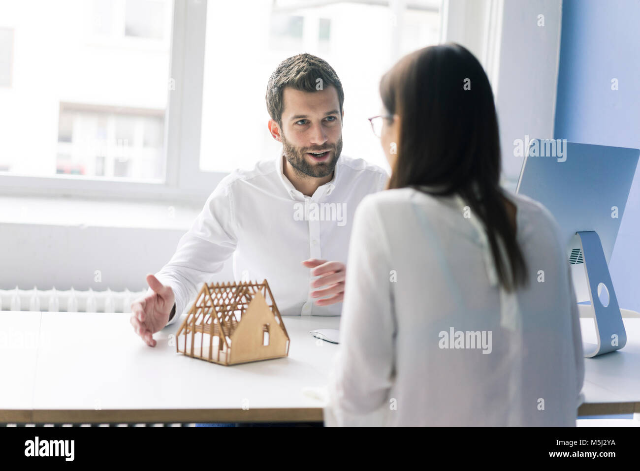 Man explaining architectural model to woman Stock Photo