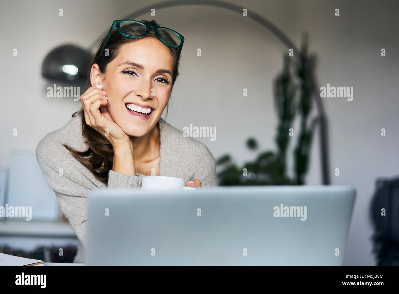 Portrait of happy young woman at home with laptop Stock Photo - Alamy