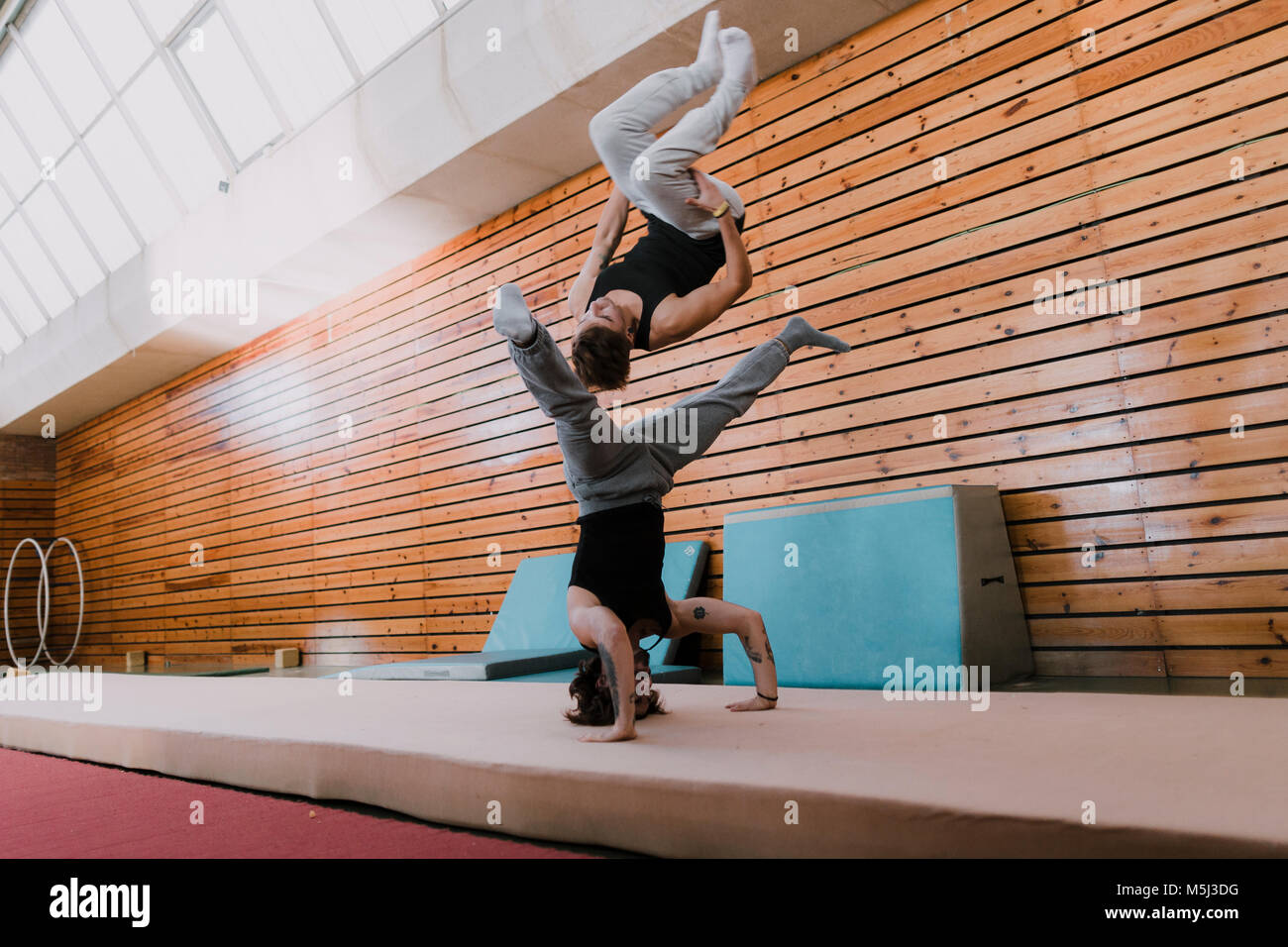 Two men doing acrobatics in gym Stock Photo