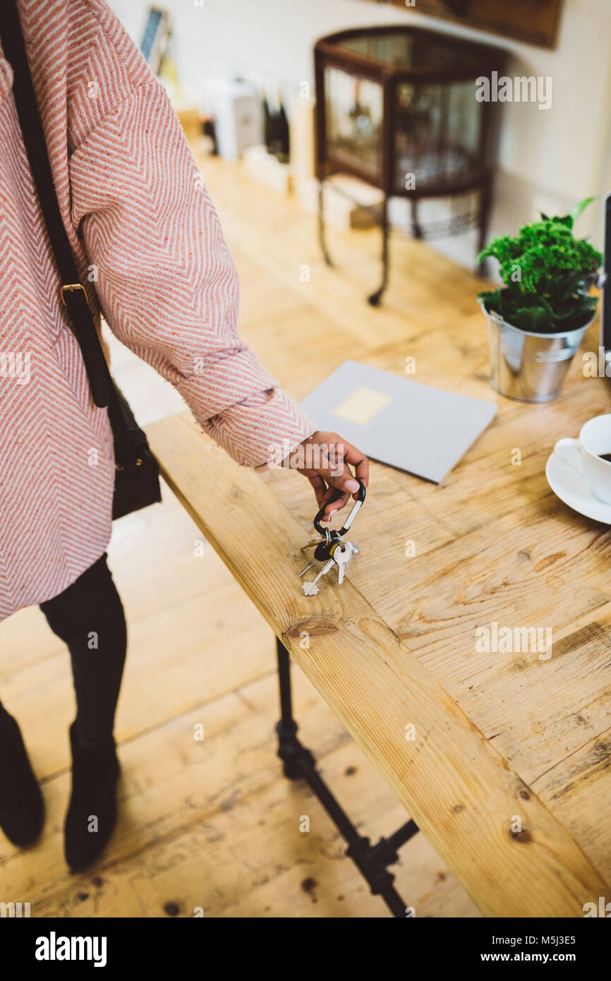 Woman coming home, putting keys on table Stock Photo