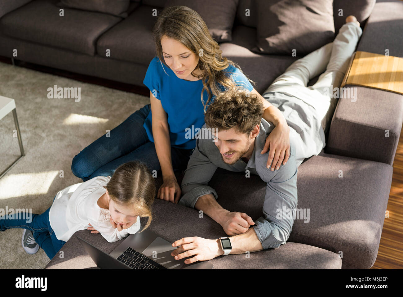Family using laptop on sofa at home Stock Photo