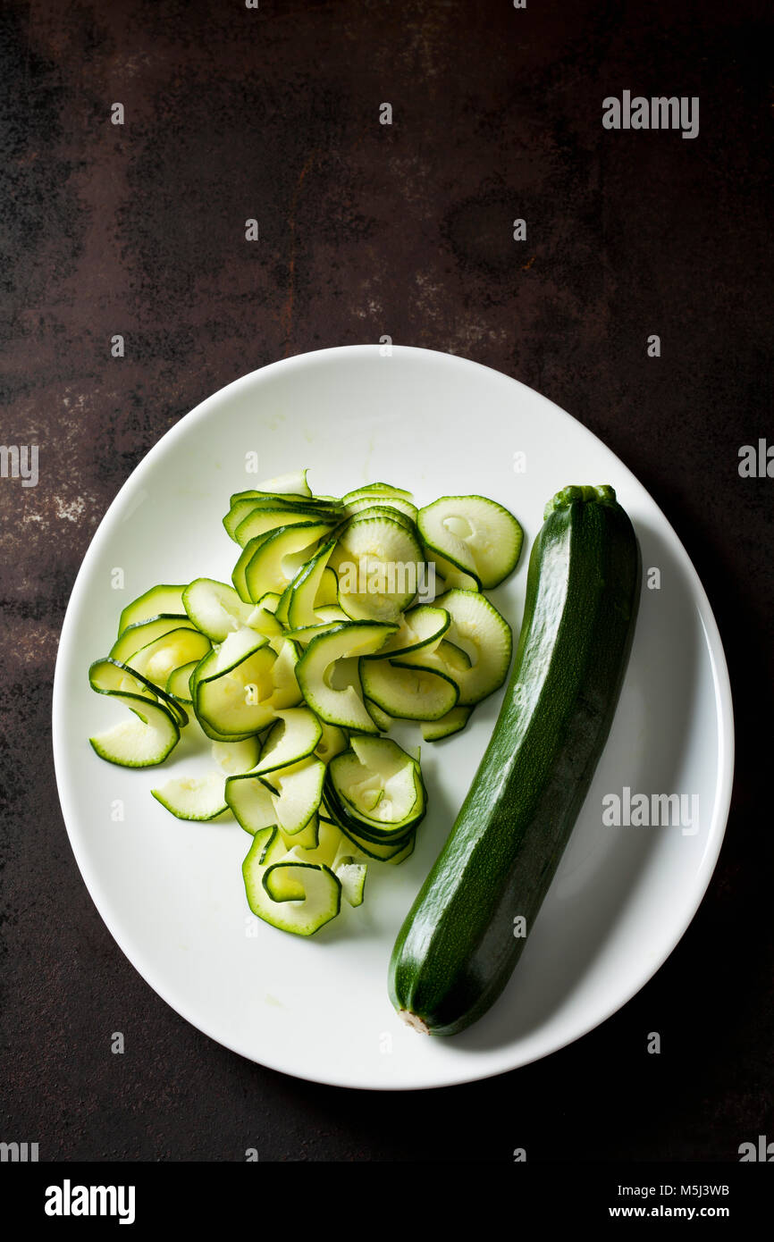 Whole and spiralized courgette on plate Stock Photo