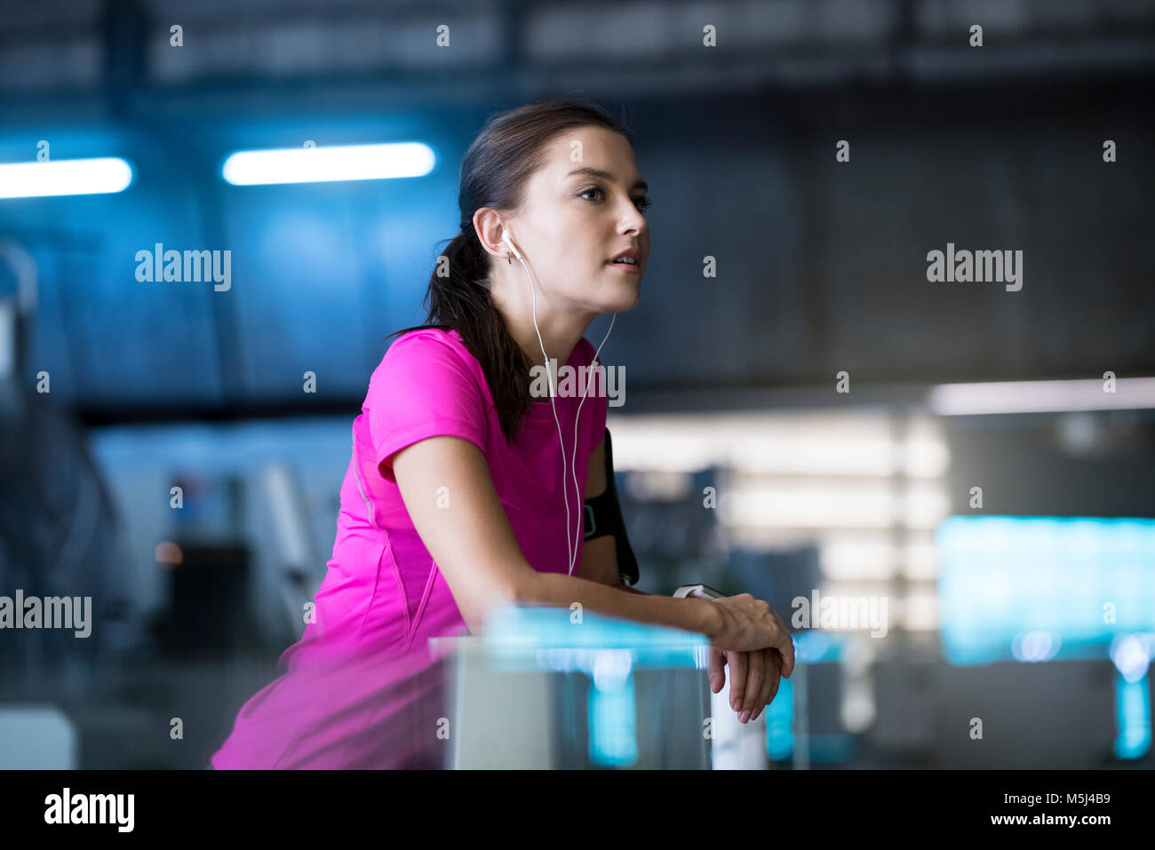 Young woman in pink sport shirt listening to music Stock Photo