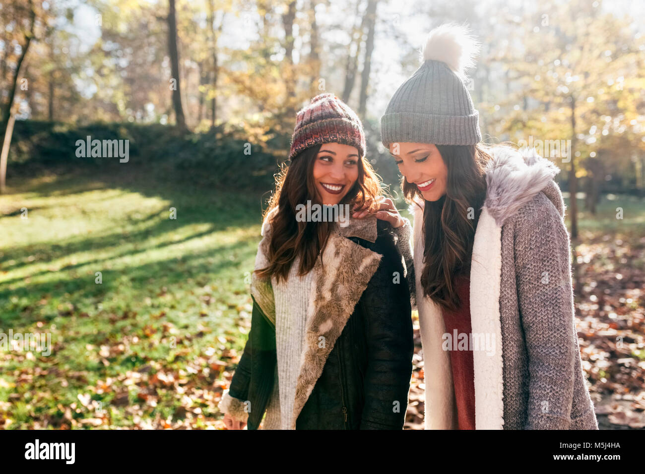 Two lovely women walking through an autumn forest Stock Photo - Alamy