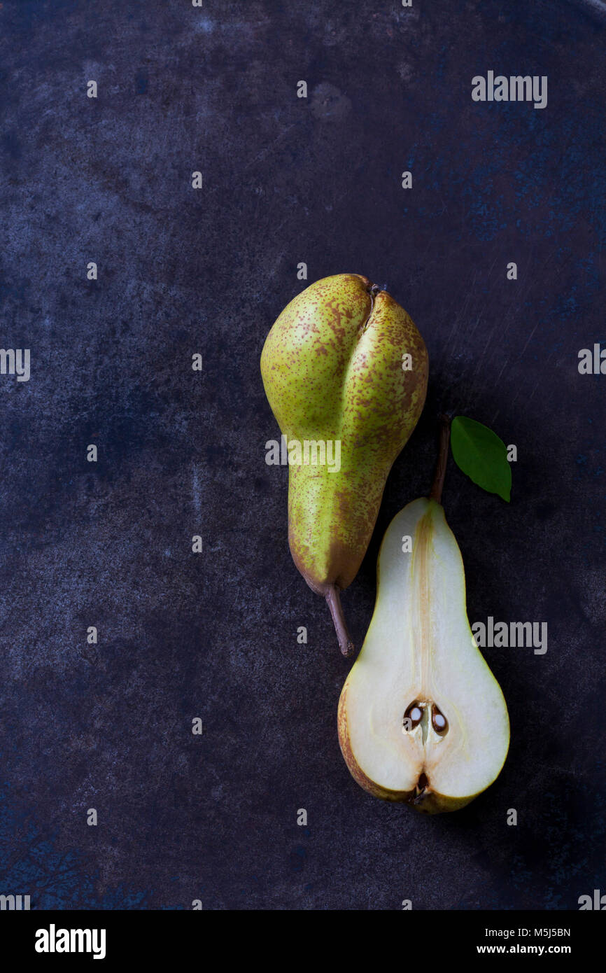 Sliced and whole pear on dark ground Stock Photo