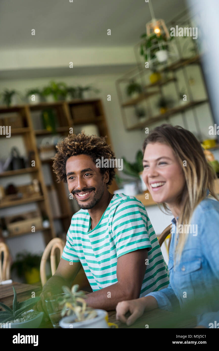 Smiling couple sitting at table in cozy cafe Stock Photo