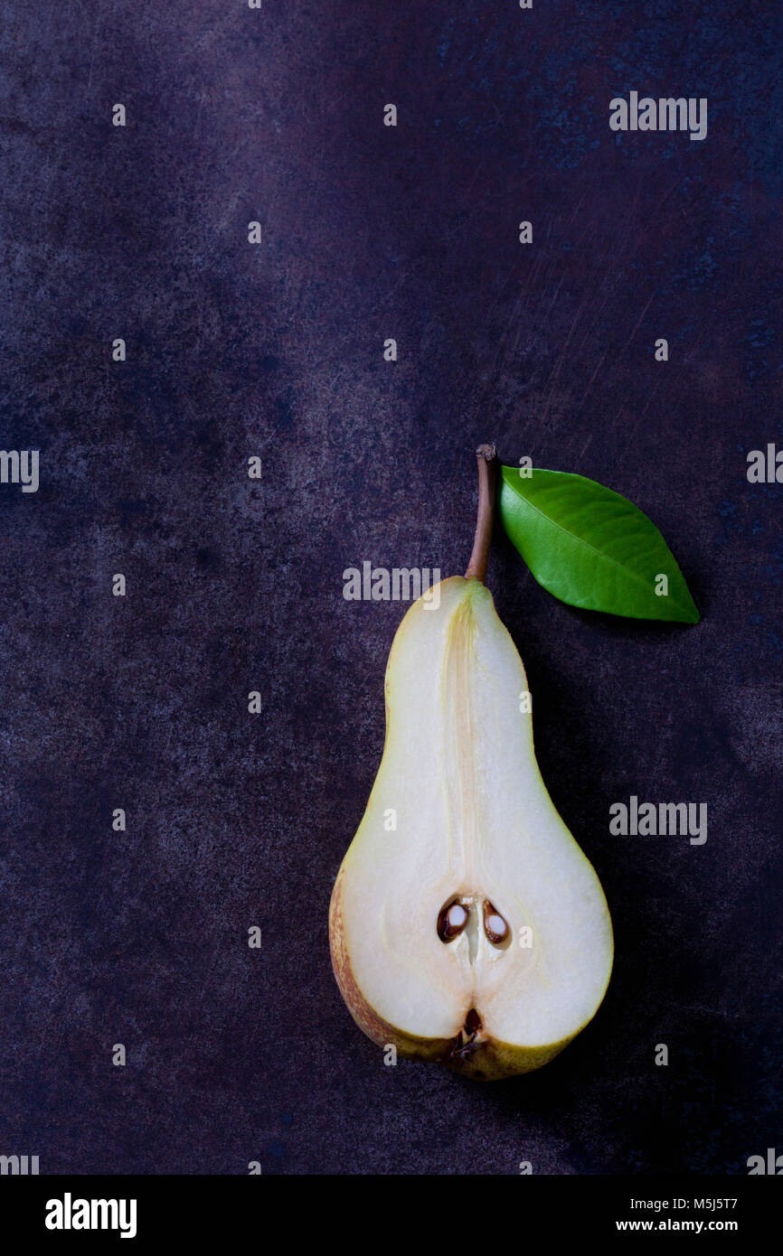 Sliced pear with leaf on dark ground Stock Photo