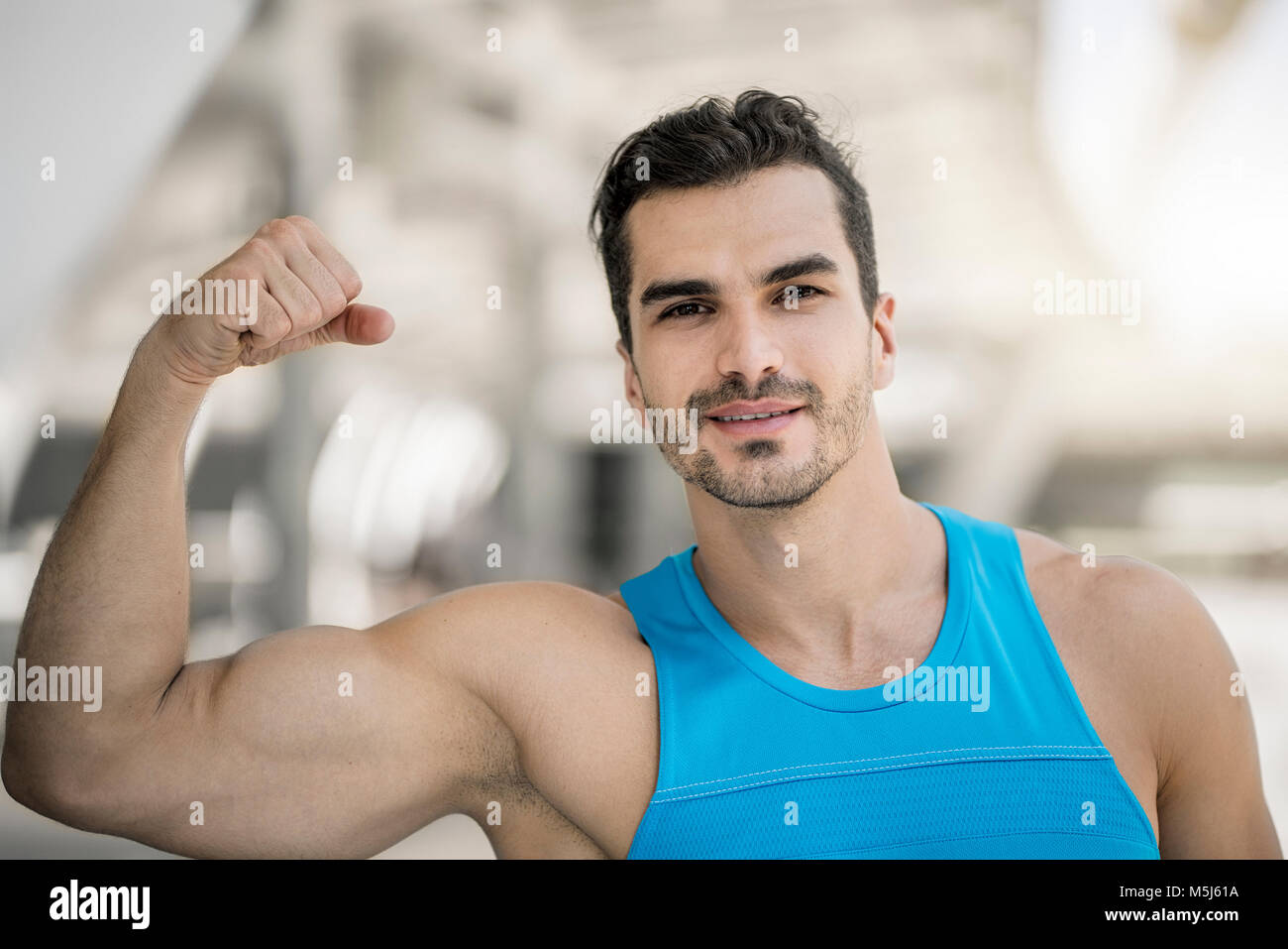 Portrait of man training in the city, flexing muscles Stock Photo
