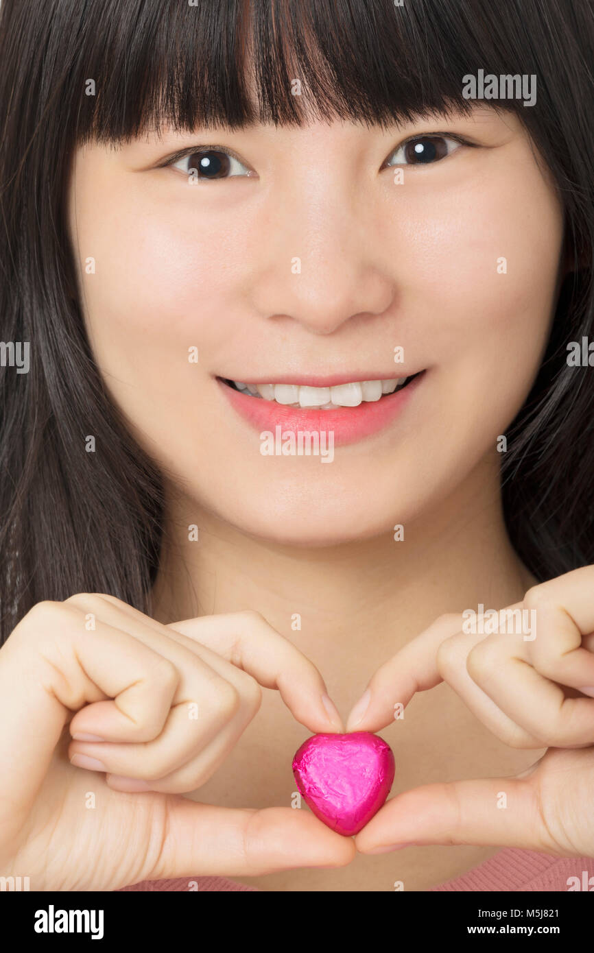 Beautiful Asian woman enjoying a special gift of chocolate candy