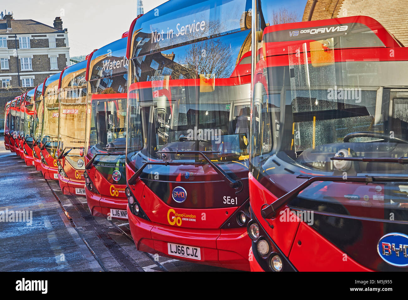 Line of red single deck buses operated by Transport for London standing in the depot close to Waterloo Station in London. Stock Photo