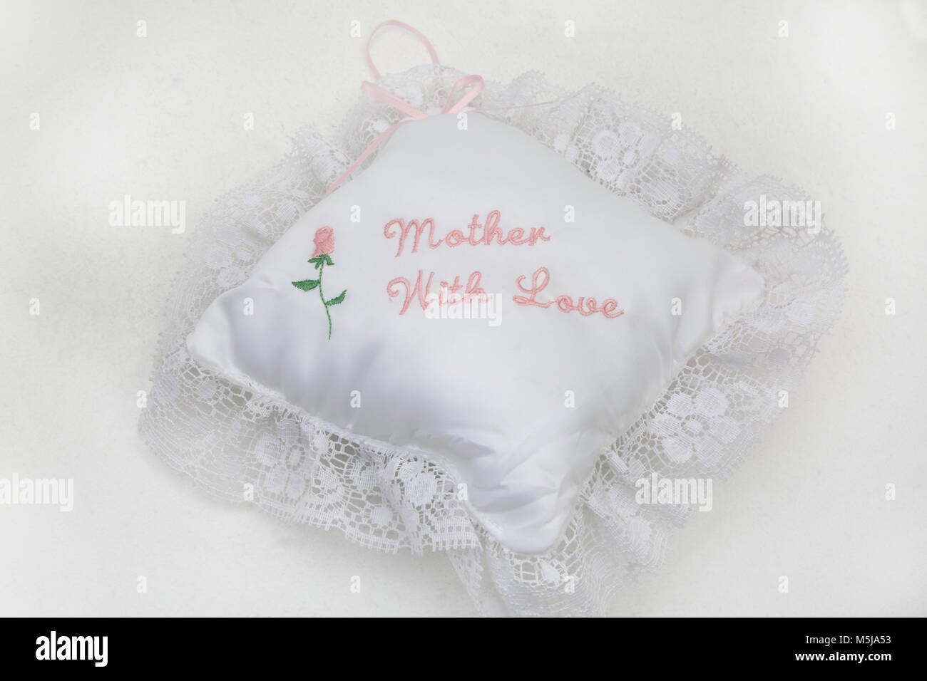 Small White Cushion with 'Mother With Love' and a Rose Embroidered With Lace Trim for a Mother's Day Gift Stock Photo