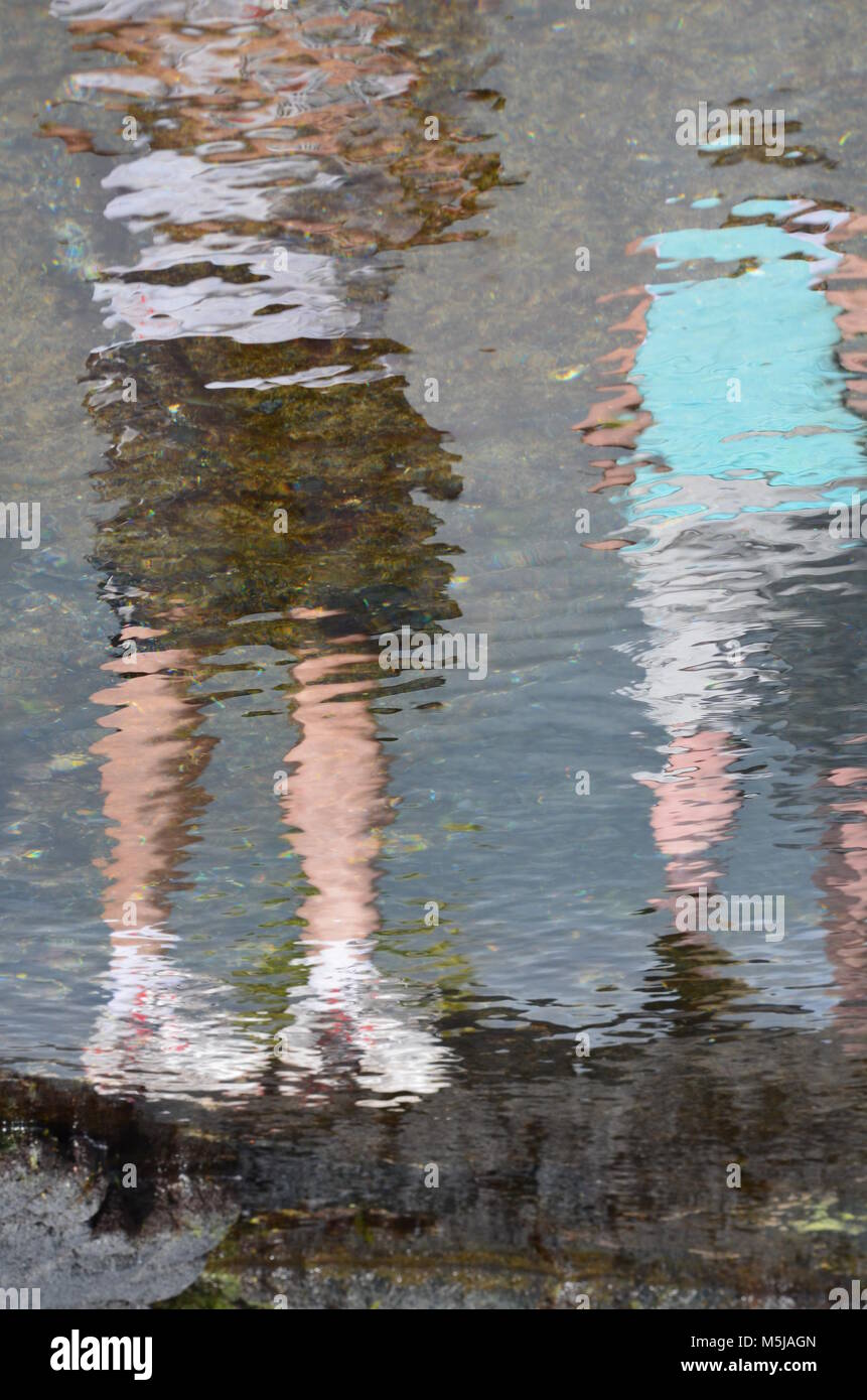 A water reflection of two people, standing side by side. Stock Photo