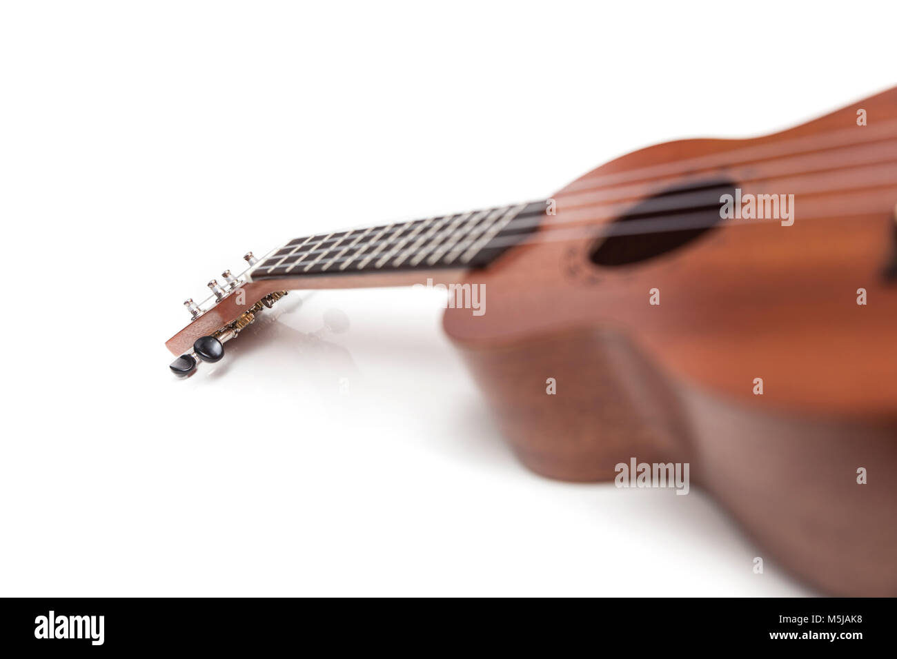The brown ukulele guitar isolated on the white background. Blurred concept Stock Photo