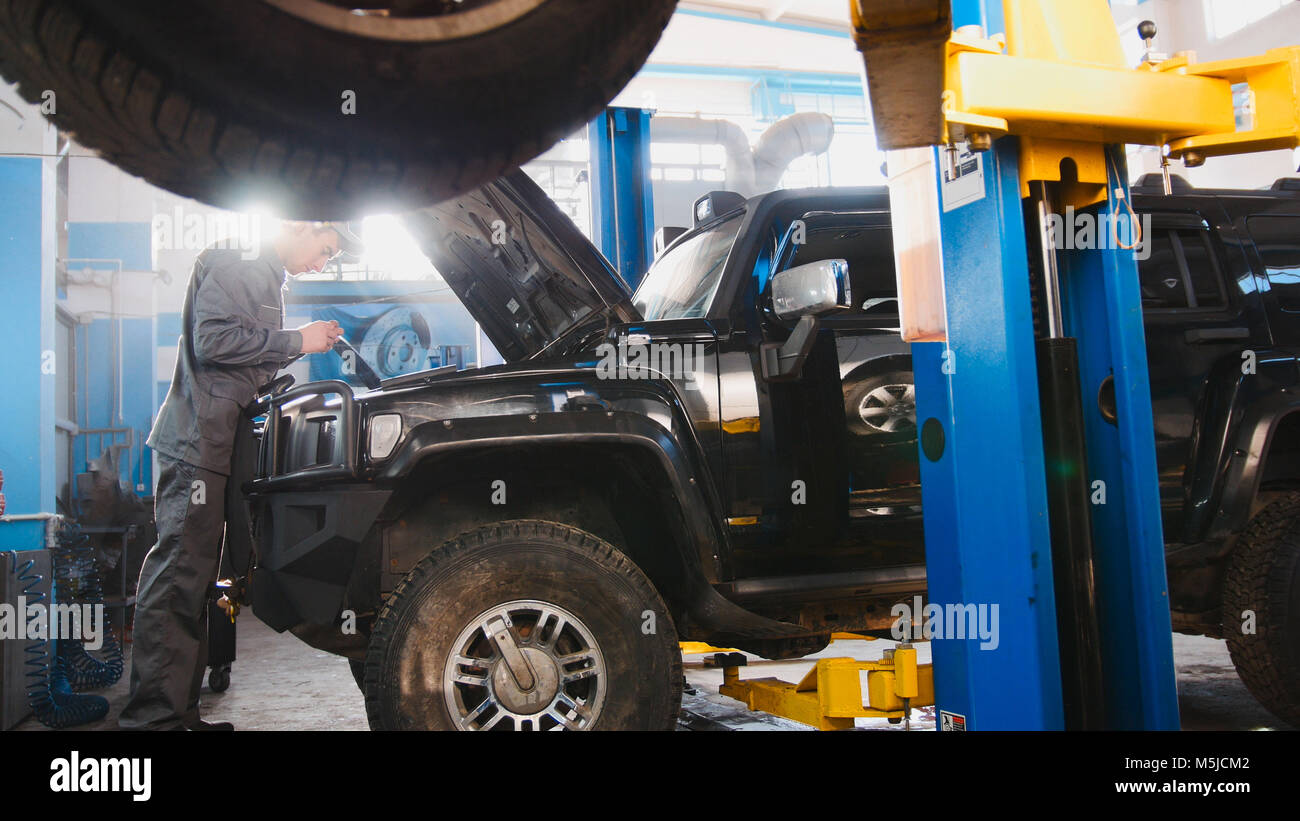 Luxury SUV standing in the garage for repairing mechanic working
