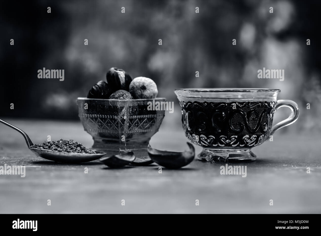 Close up of Nutmeg,Jaiphal,Myristica fragrans in a glass container with its powder and tea in a cup. Stock Photo