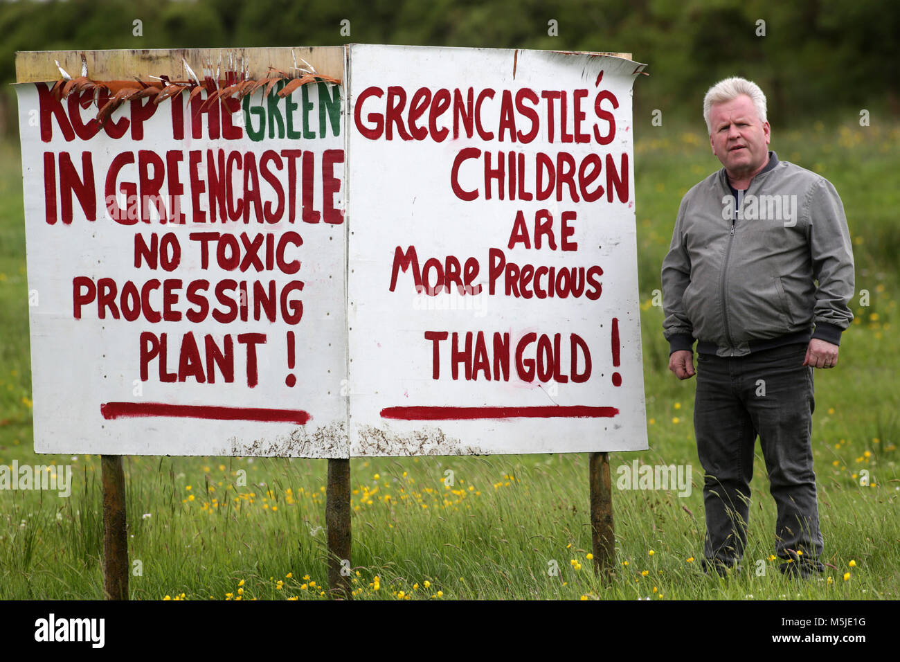 GOLD MINING IN THE SPERRINS, NORTHERN IRELAND - 15-JUNE-2017 - Campaigner and Green Party activist Ciaran McClean stands beside a sign protesting at the building of a plant which is said to deal with the waste from the mining. Stock Photo