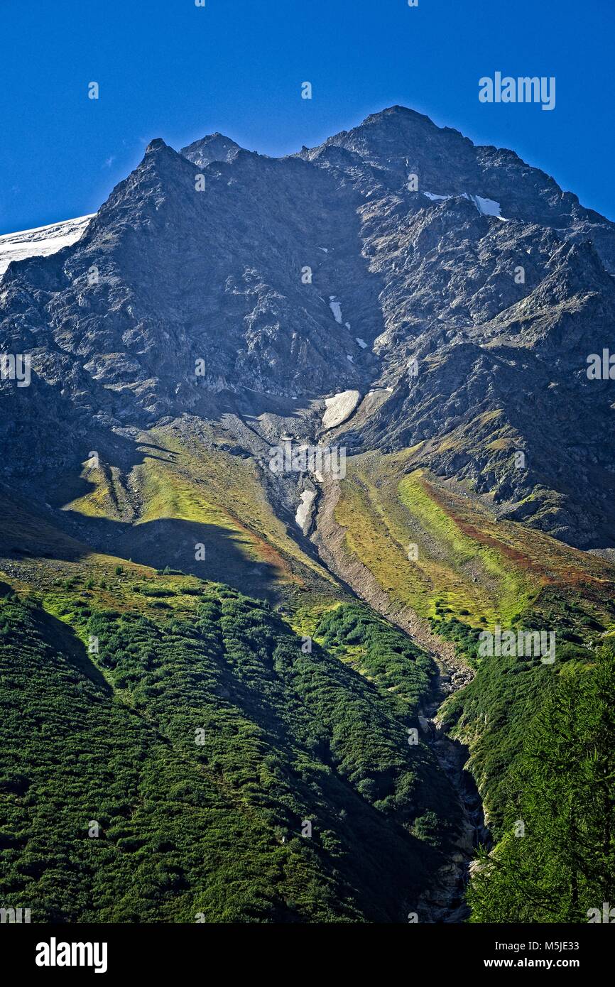 Gully erosion into scree slopes as a result of melt water from snow.Swiss Alps near Wassen and Meiental. Stock Photo