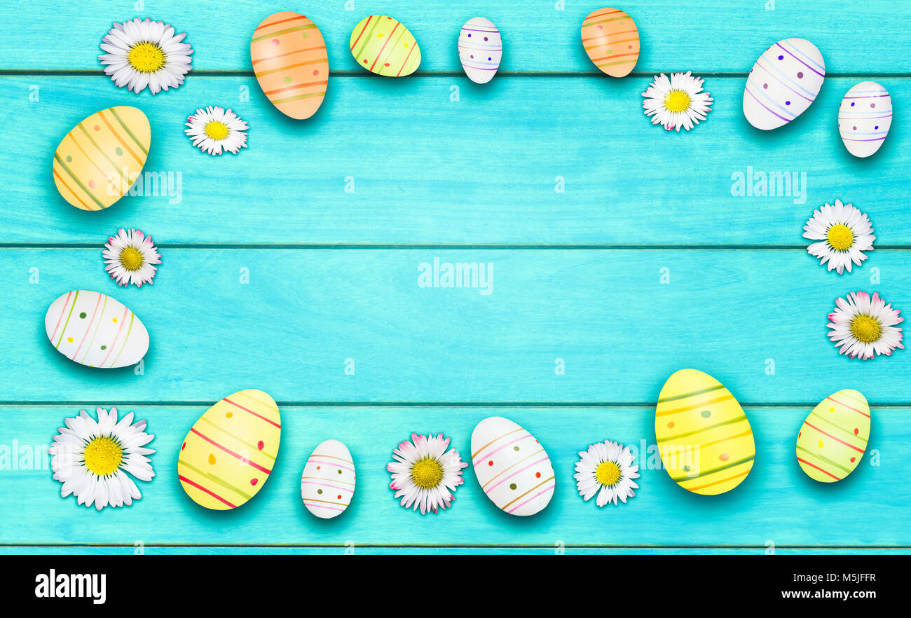 daisies and easter eggs on wooden cyan background Stock Photo