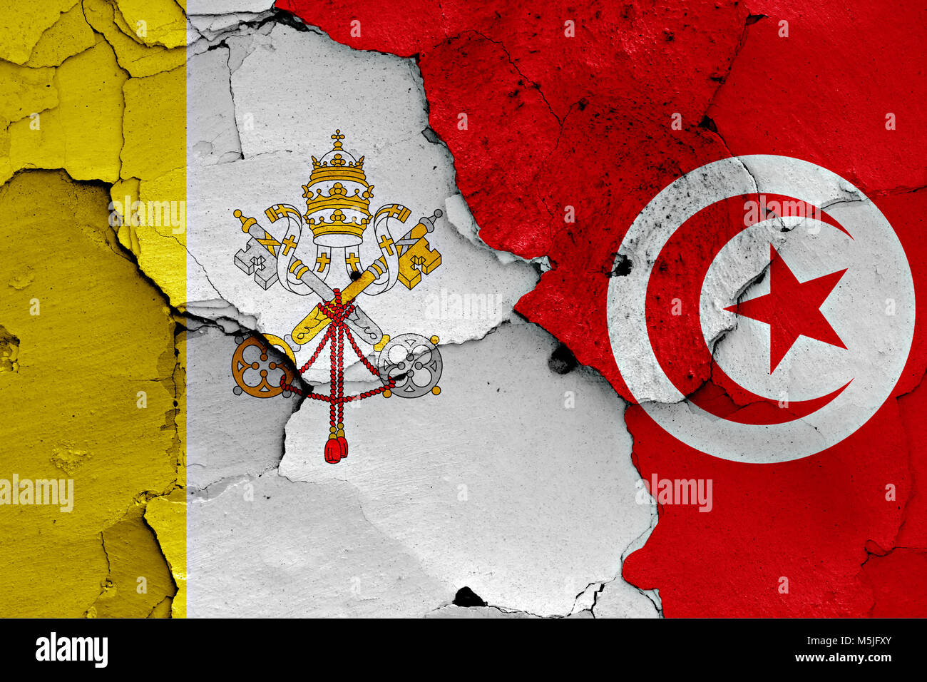 flag of Vatican and Tunisia painted on cracked wall Stock Photo