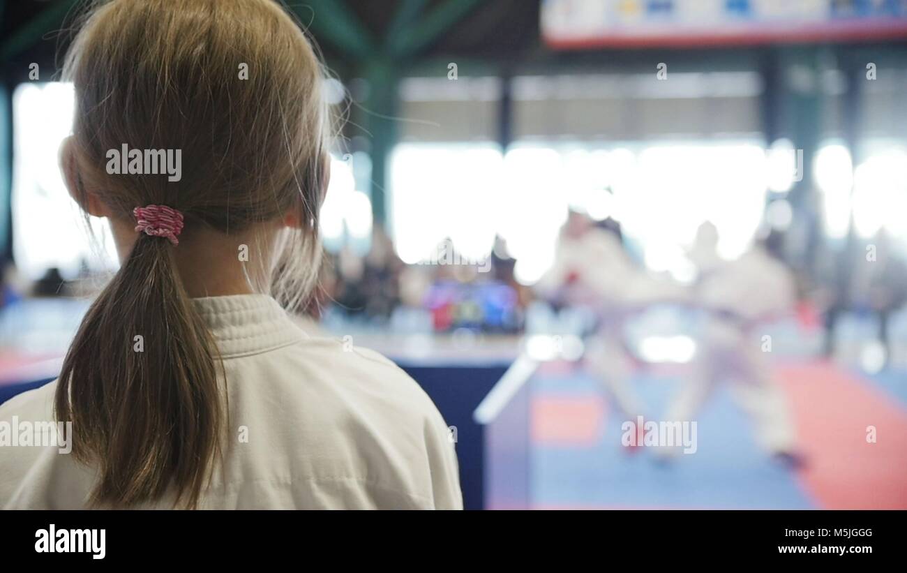 Teenager karate sports girl looking to fight on tatami spectator