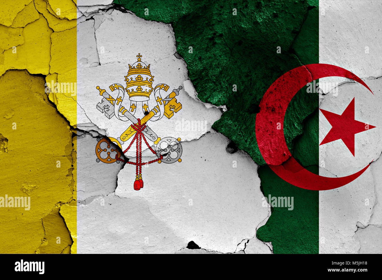 flag of Vatican and Algeria painted on cracked wall Stock Photo