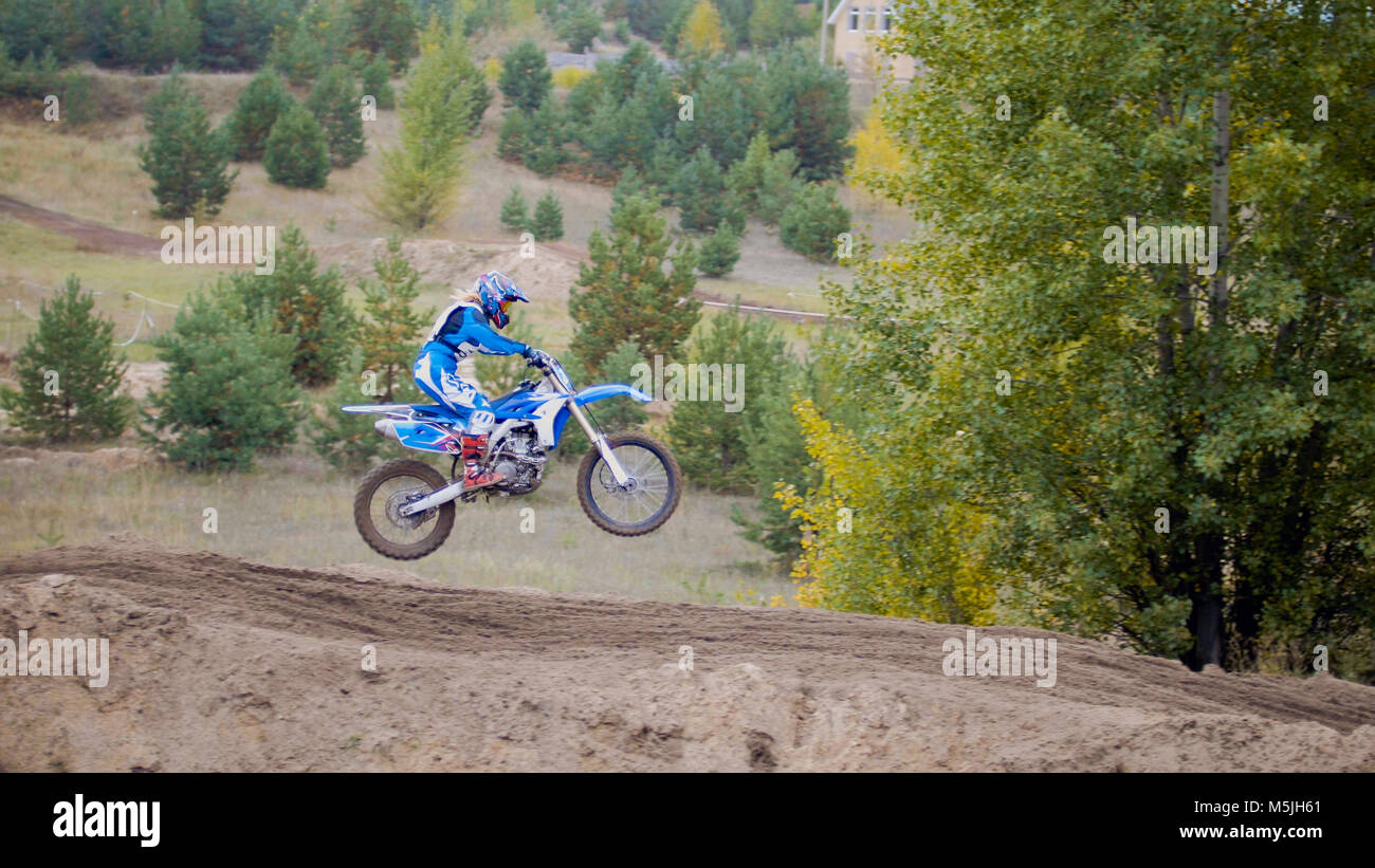 MX moto cross racing - Girl Bike Rider rides on a dirt motorcycle - extreme jump Stock Photo