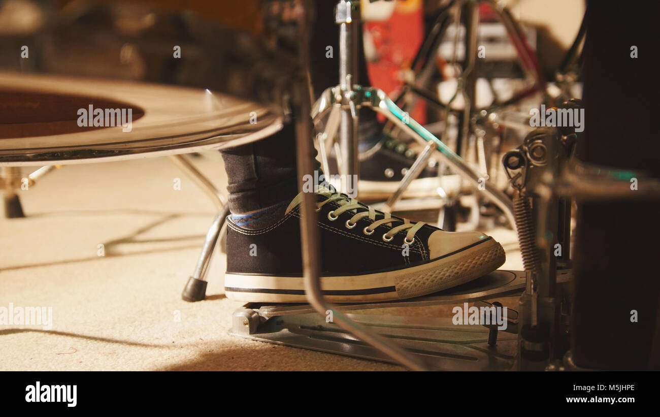 Rock band rehearsing in the garage drummer's foot wears sneakers