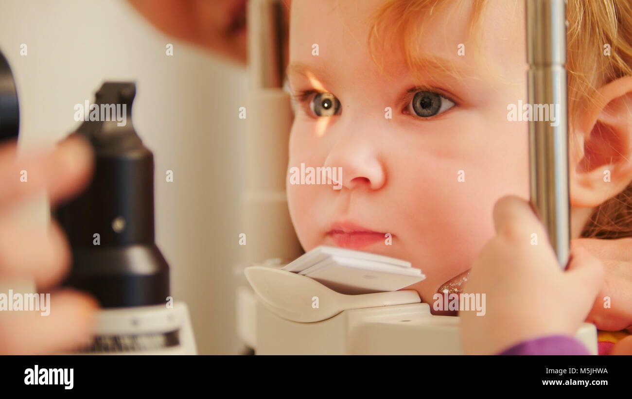 Child's optometry concept - little girl checks eyesight in eye ophthalmological clinic Stock Photo