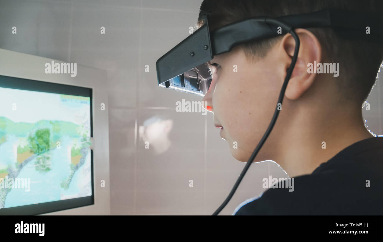 Ophthalmology child checks eyes with stereo glasses and monitor Stock
