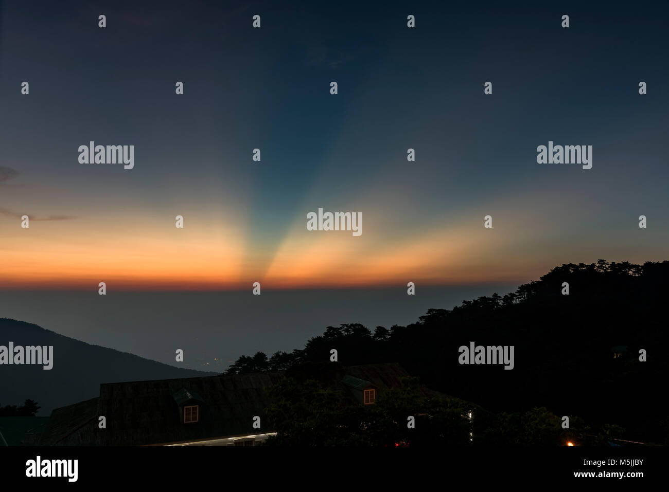 Sunset at Lushan, in Jiangxi Province. Not sure where the rays of diffirent hues came from. Stock Photo