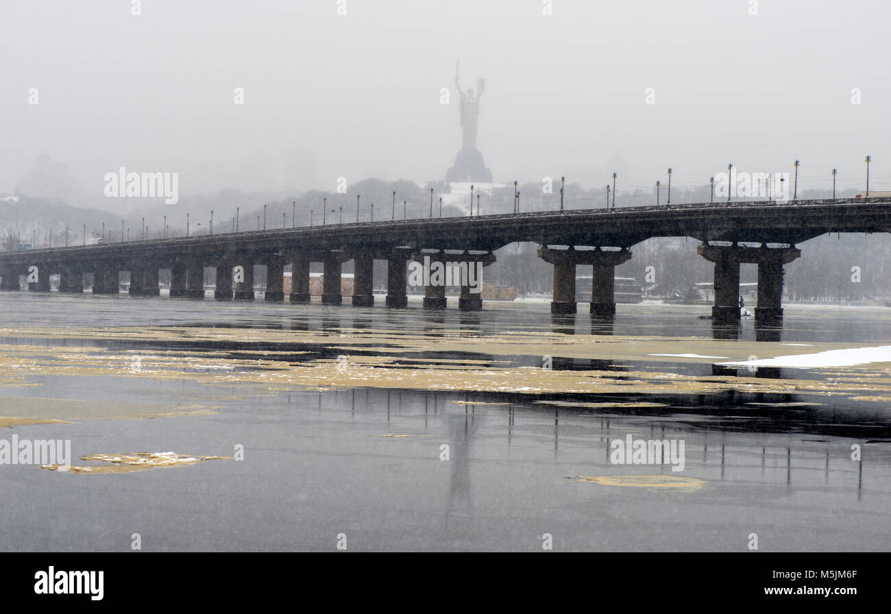 View of the Paton Bridge in winter. Snowfall in Kiev near the Dnieper River. Timelapse Stock Photo