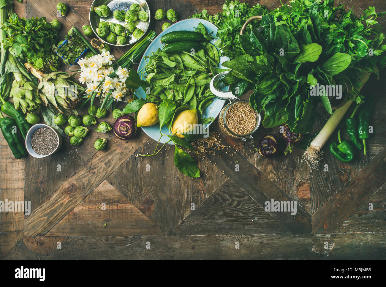 Spring healthy vegan food cooking ingredients over wooden background Stock Photo