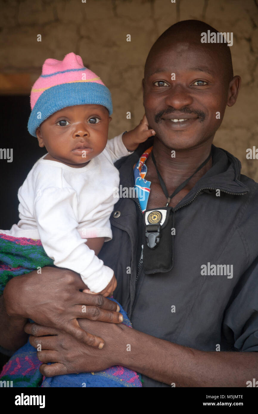 Smiling father holds his baby in rural Sierra Leone Stock Photo