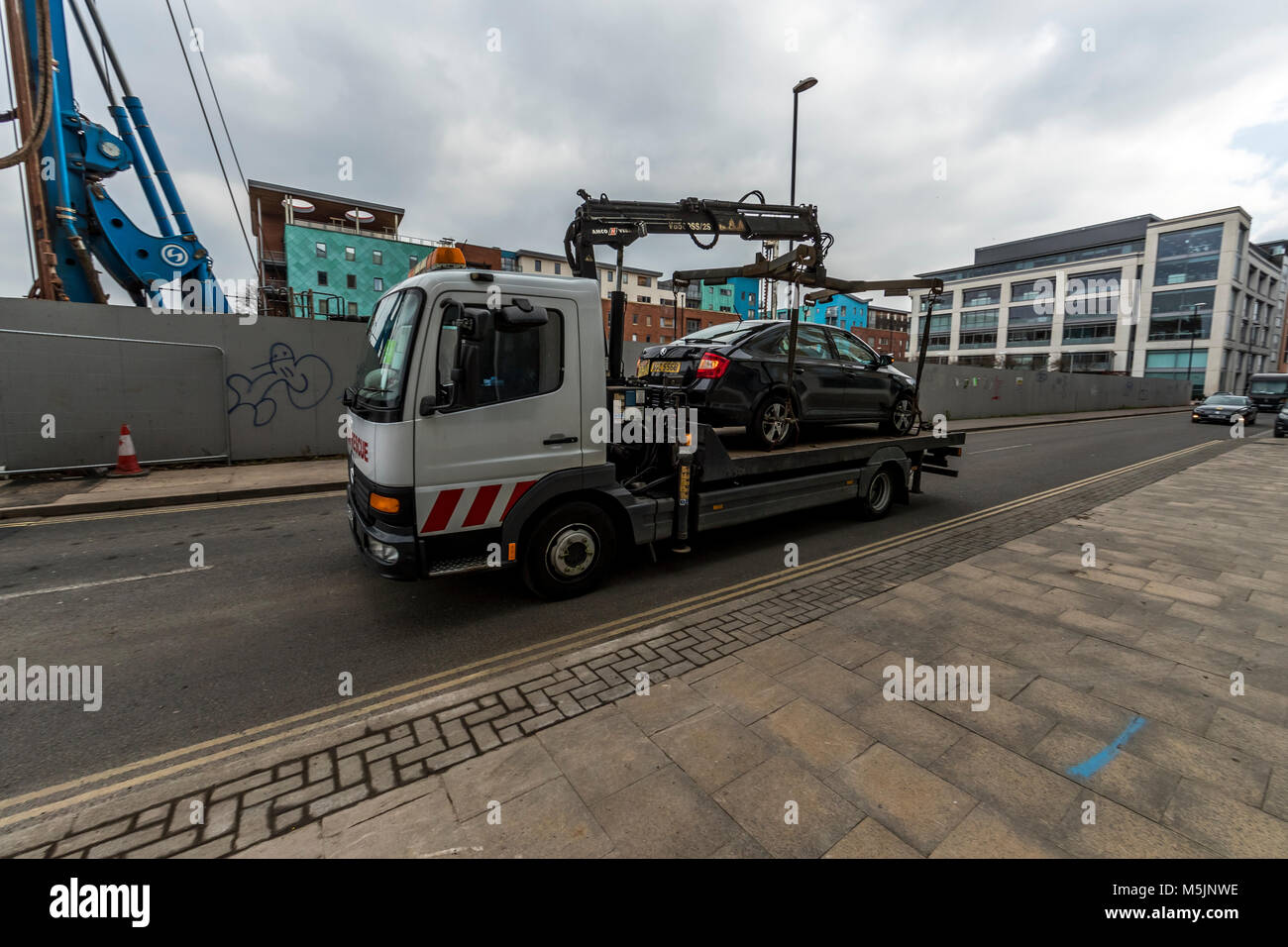 A taxi being moved by lorry after having been lifted on. Stock Photo