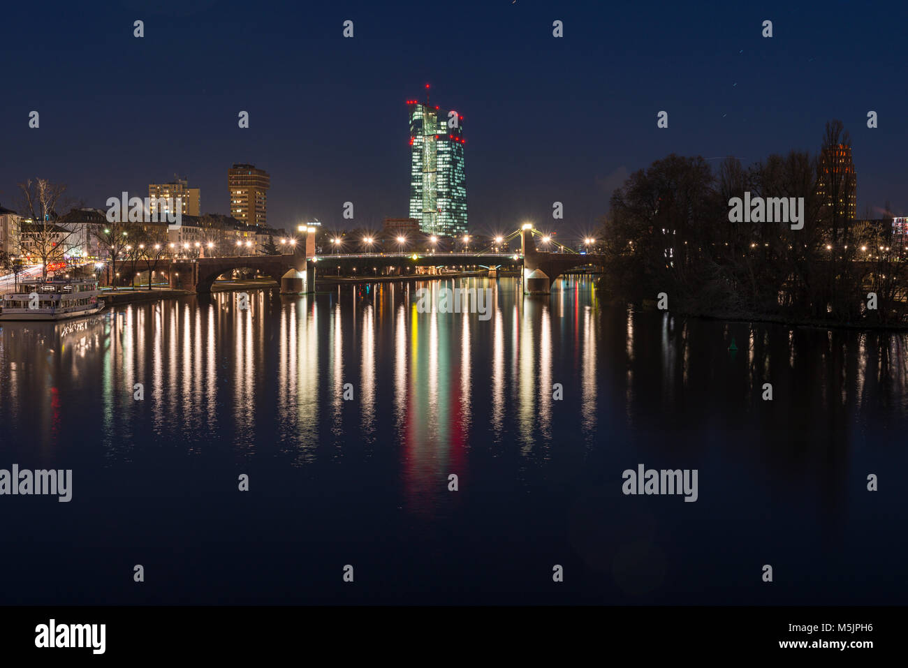 View from the Eiserner Steg over the River Main to the illuminated European Central Bank at night,ECB,Frankfurt am Main,Hesse Stock Photo